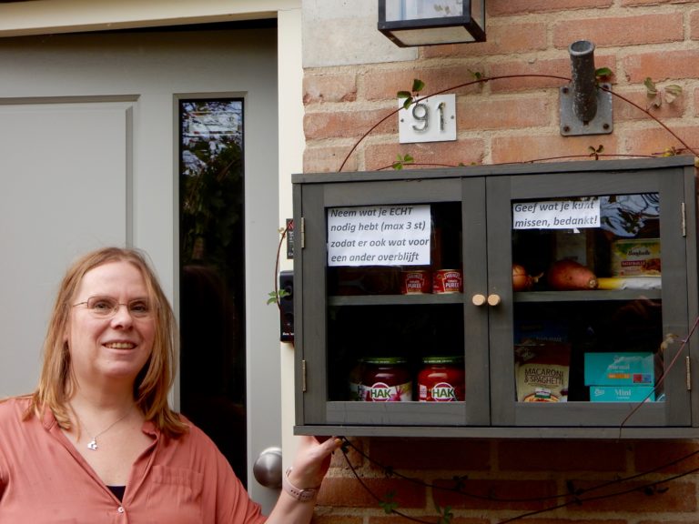 Ingrid bij haar deelkastje met verschillende producten